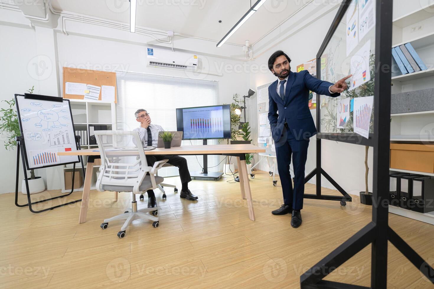 In a contemporary office, two senior executives with a mission to brainstorm and monitor,19 photo