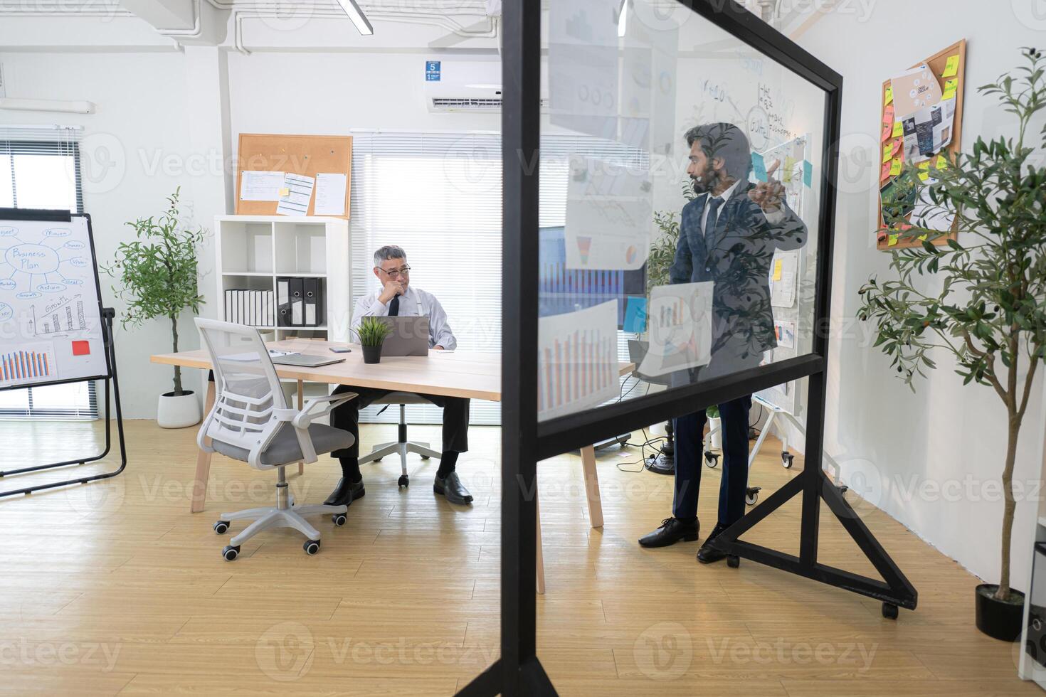 In a contemporary office, two senior executives with a mission to brainstorm and monitor,11 photo