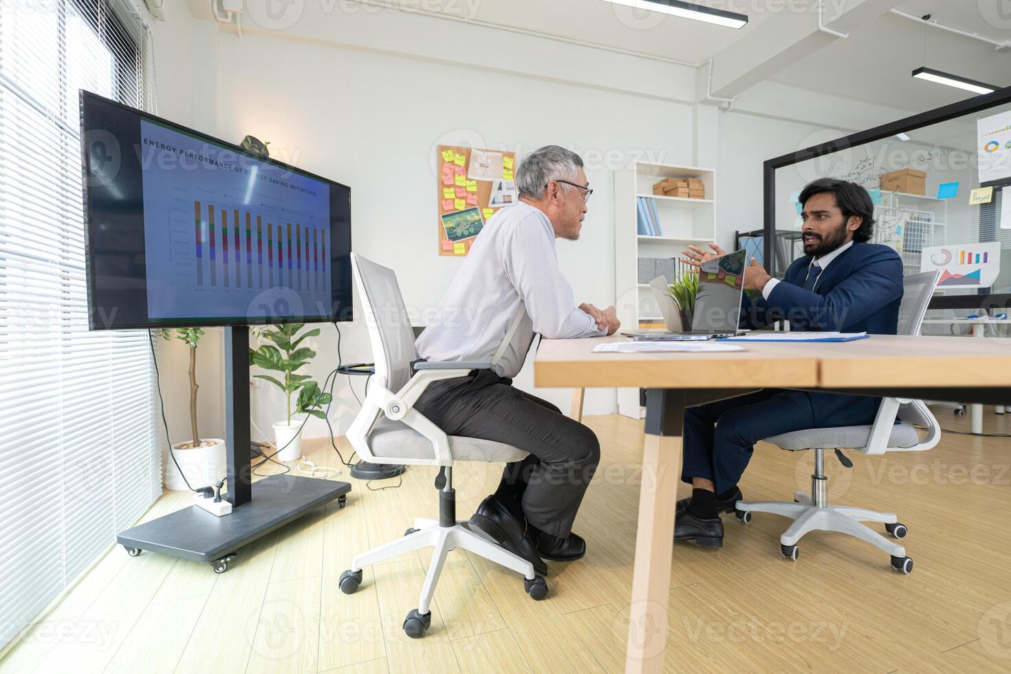 In a contemporary office, two senior executives with a mission to brainstorm and monitor,8 photo