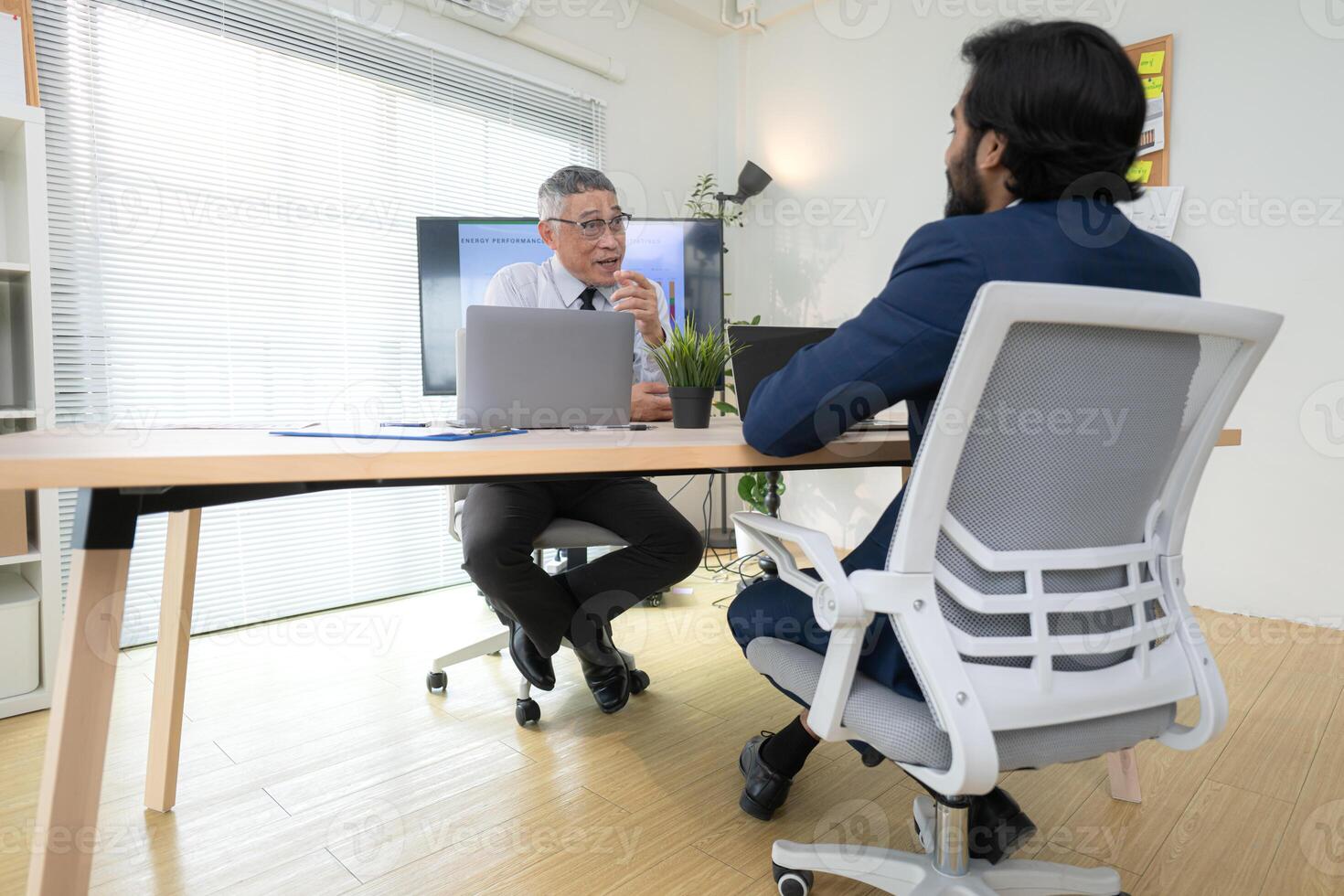 In a contemporary office, two senior executives with a mission to brainstorm and monitor,2 photo