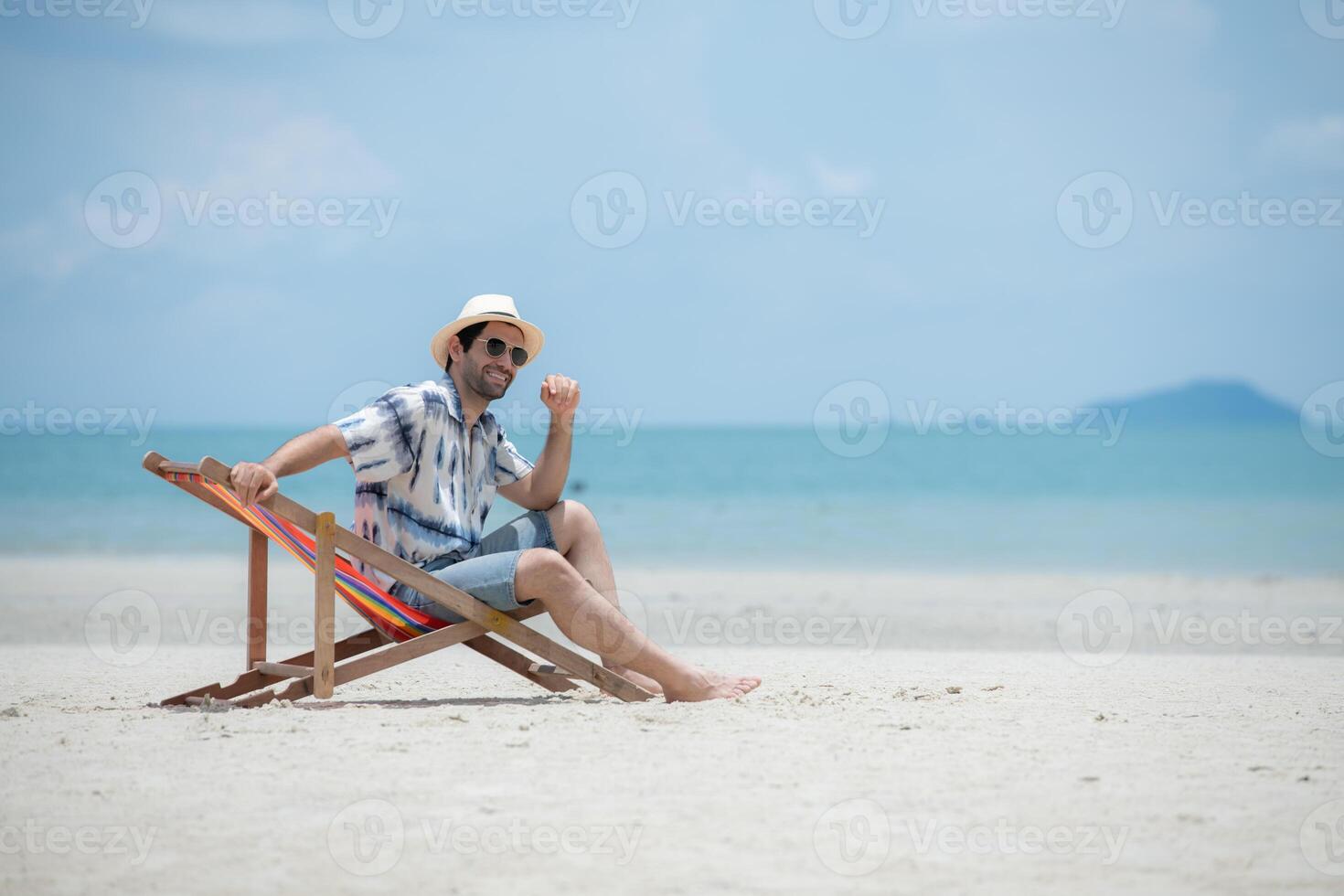 Young man on vacation on a white sandy beach, clear sky and sea,165 photo