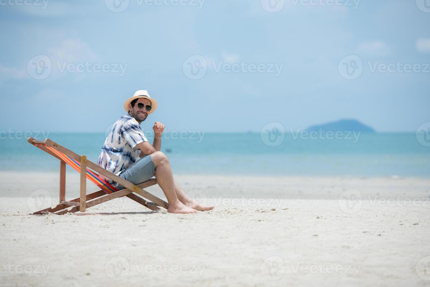 Young man on vacation on a white sandy beach, clear sky and sea,150 photo