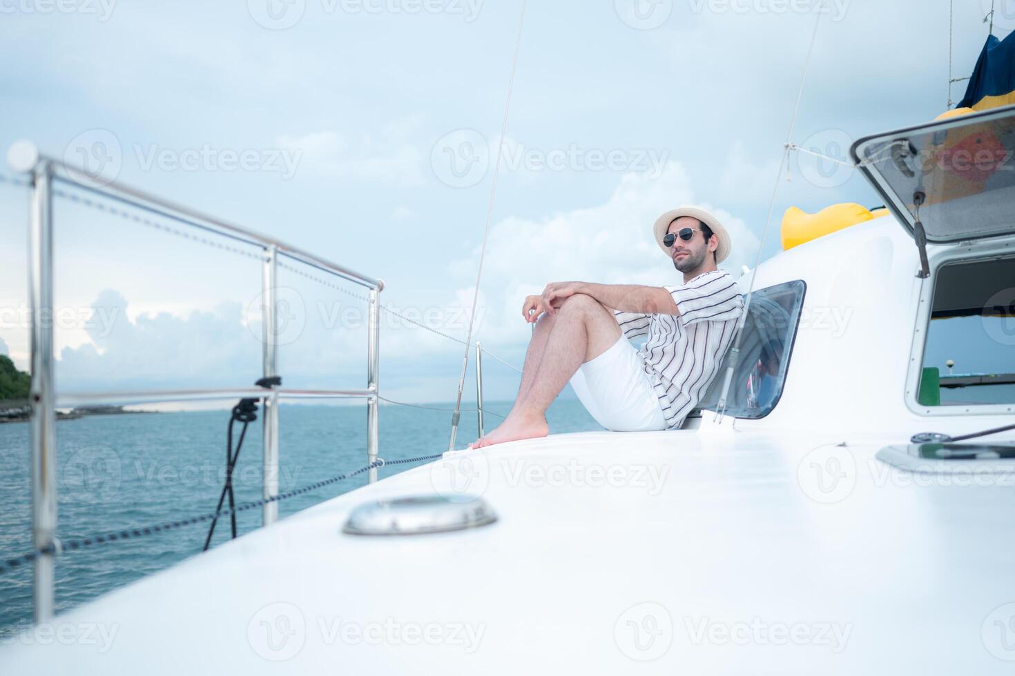 A young man is enjoying his seaside adventure aboard a yacht,125 photo