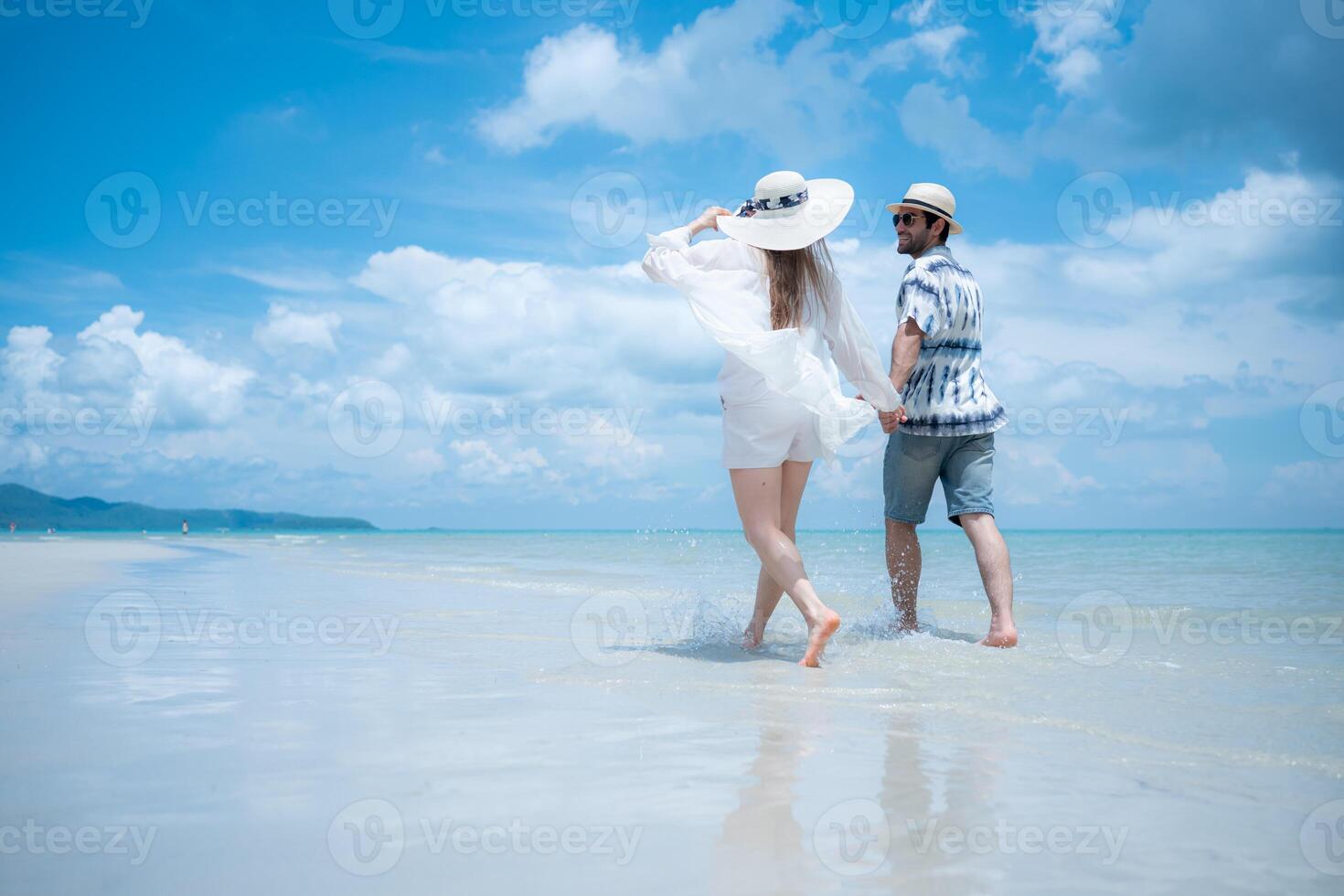 Young couple on vacation on a white sandy beach, clear sky and sea,63 photo