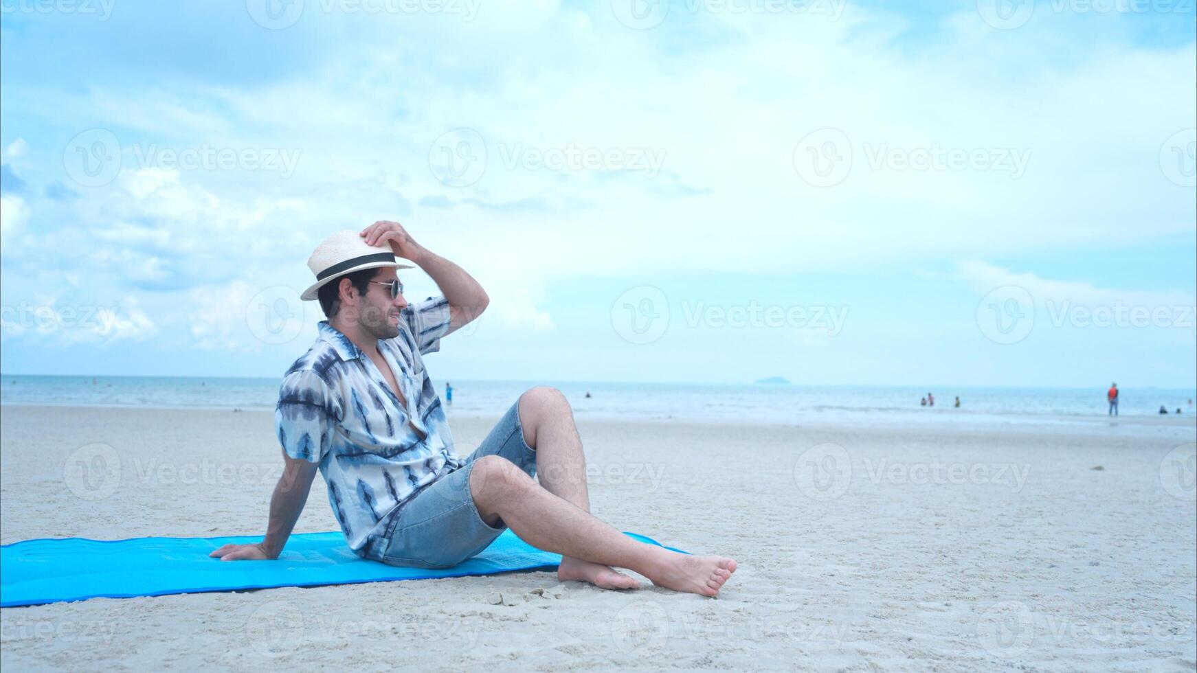 Young man on vacation on a white sandy beach, clear sky and sea,44 photo