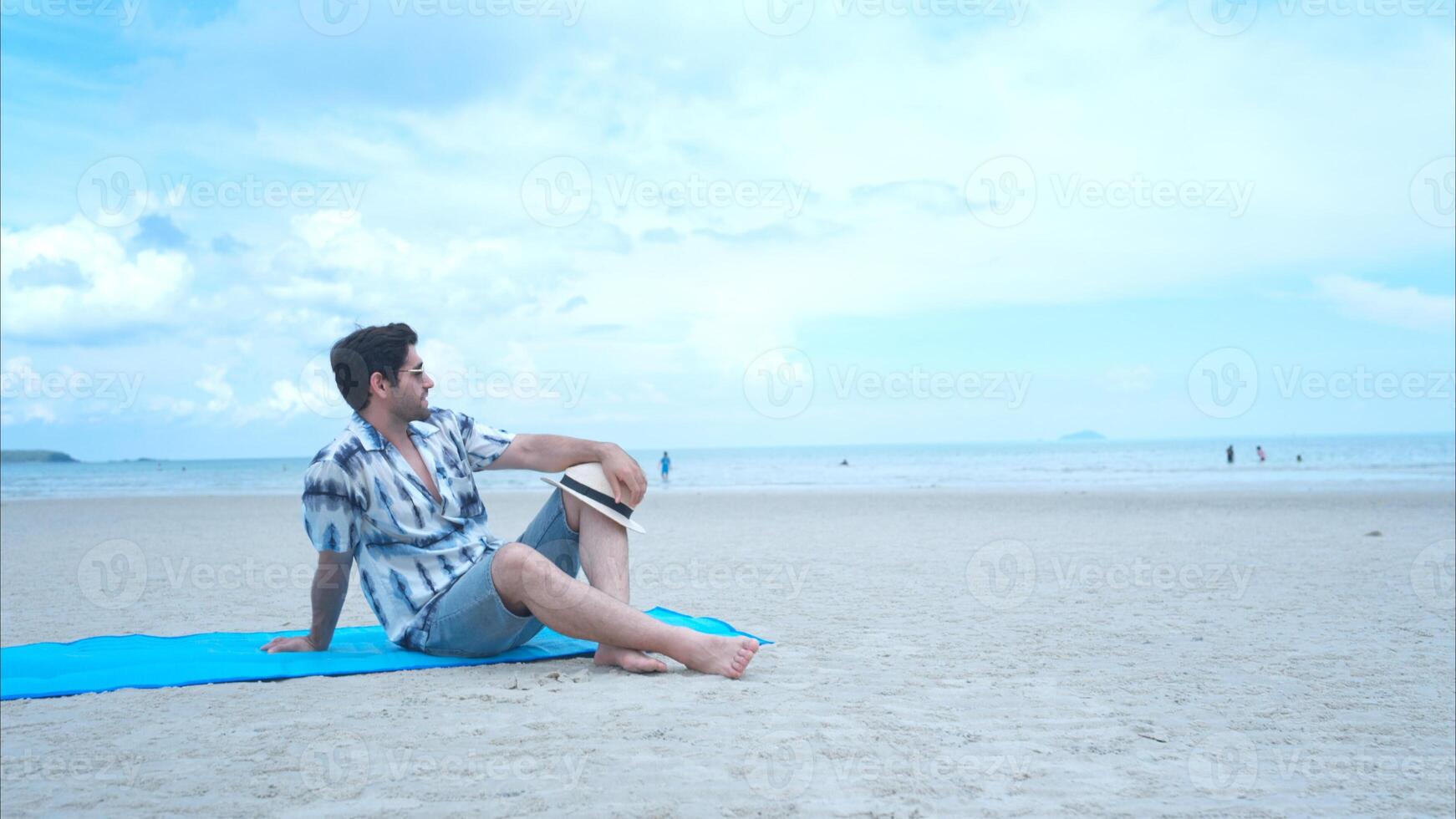 Young man on vacation on a white sandy beach, clear sky and sea,13 photo