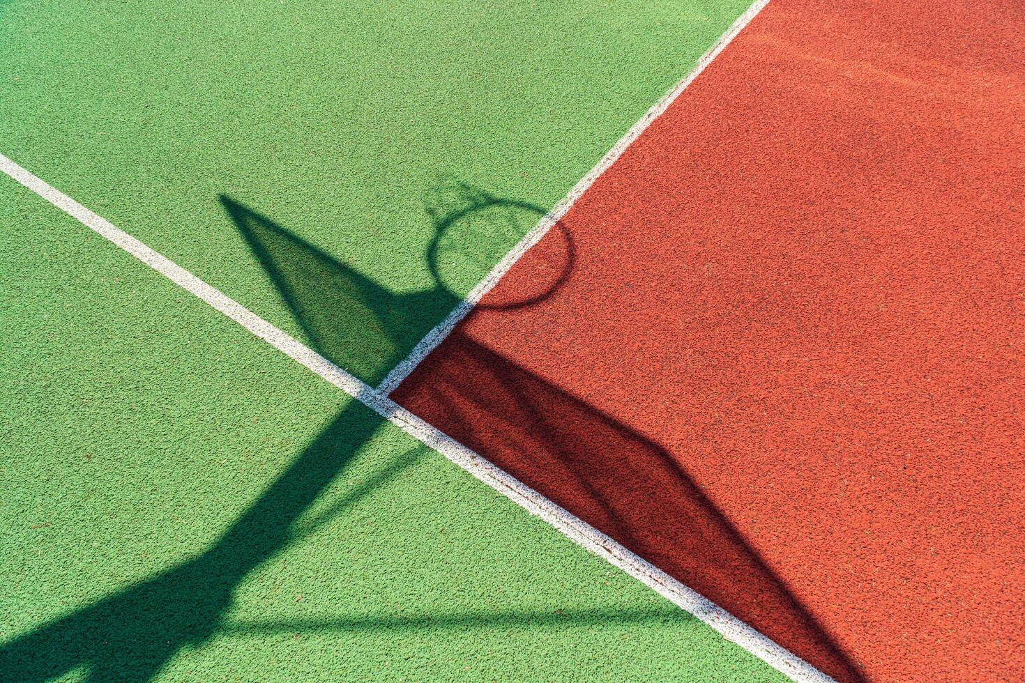 Colorful basketball court. Shadow of the rack with shield and basketball ring photo