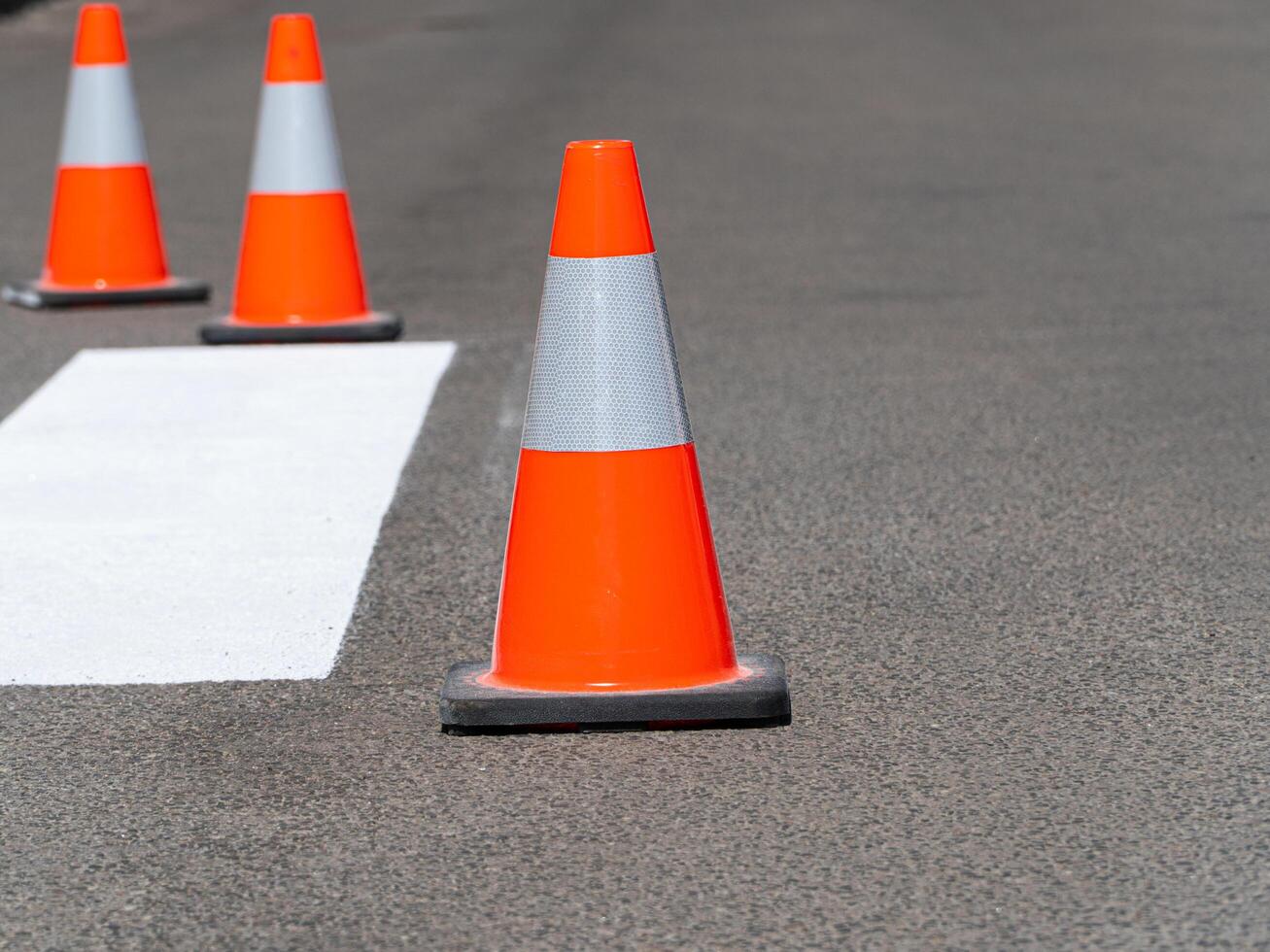 Three traffic cones on road photo