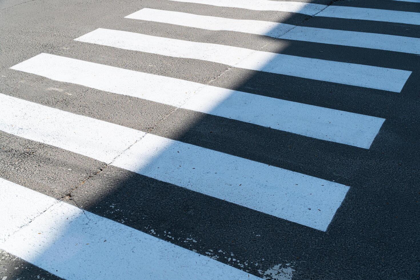 Crosswalk. New white lines of the pedestrian crossing. Application of markings on a pedestrian crossing over an asphalt road. photo