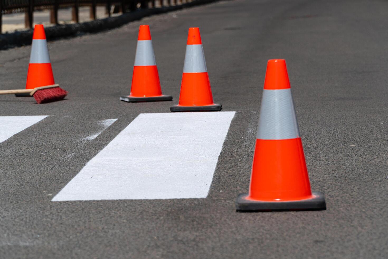Repair a pedestrian crossing on an asphalt surface on a city street. Work on road. Construction cone photo
