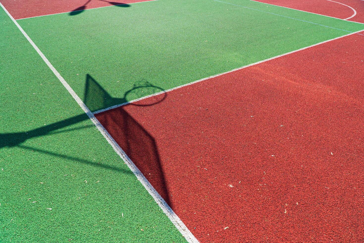 Shadow of the rack with shield and basketball ring on basketball field. Colorful basketball lines on an outdoor court photo
