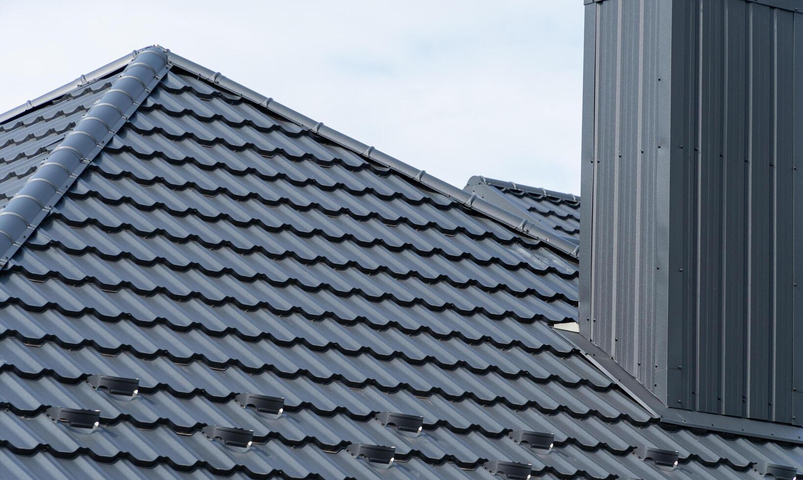 A fragment of the roof made of metal roof tiles. Modern roof made of metal photo