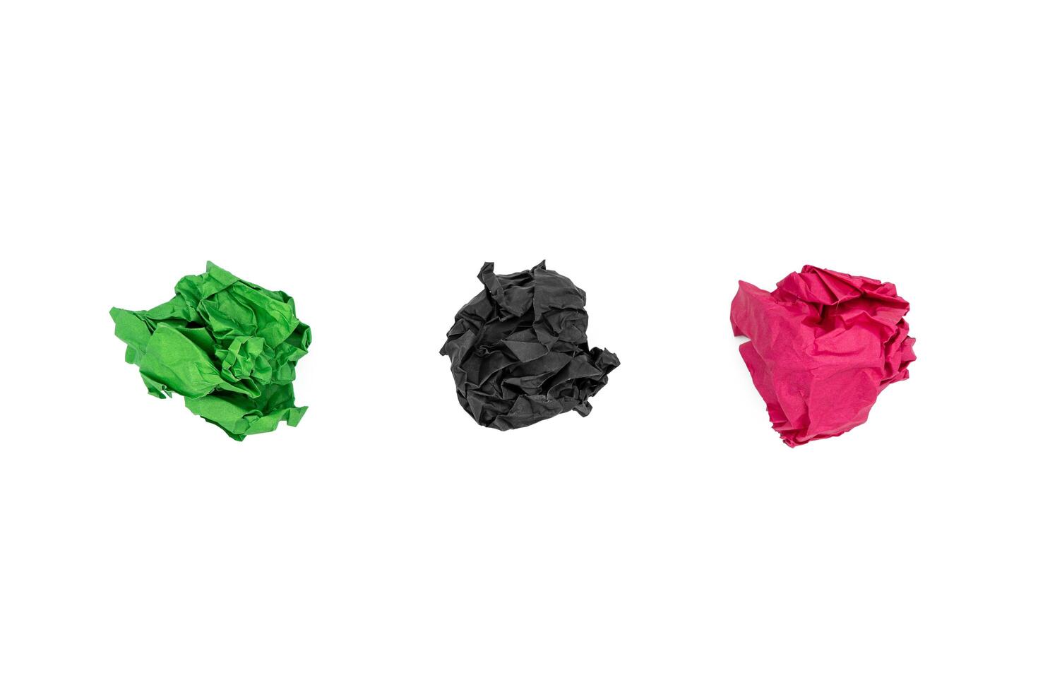 Multiple colorful crumpled paper ball isolated on white. Green, black and red. Flat lay design photo
