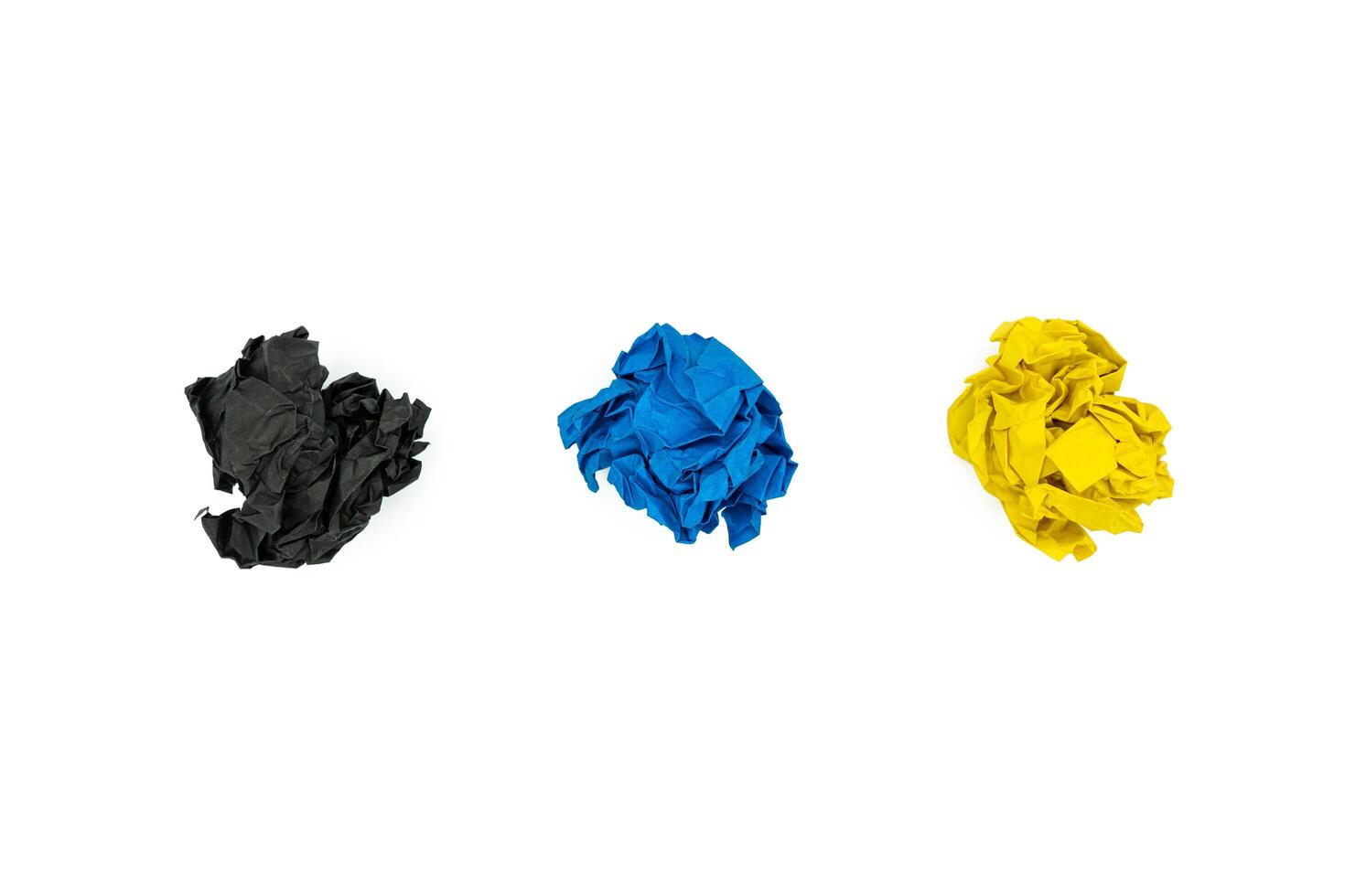 Three colorful crumpled paper balls isolated on white background. Black, blue and yellow wrinkled paper photo