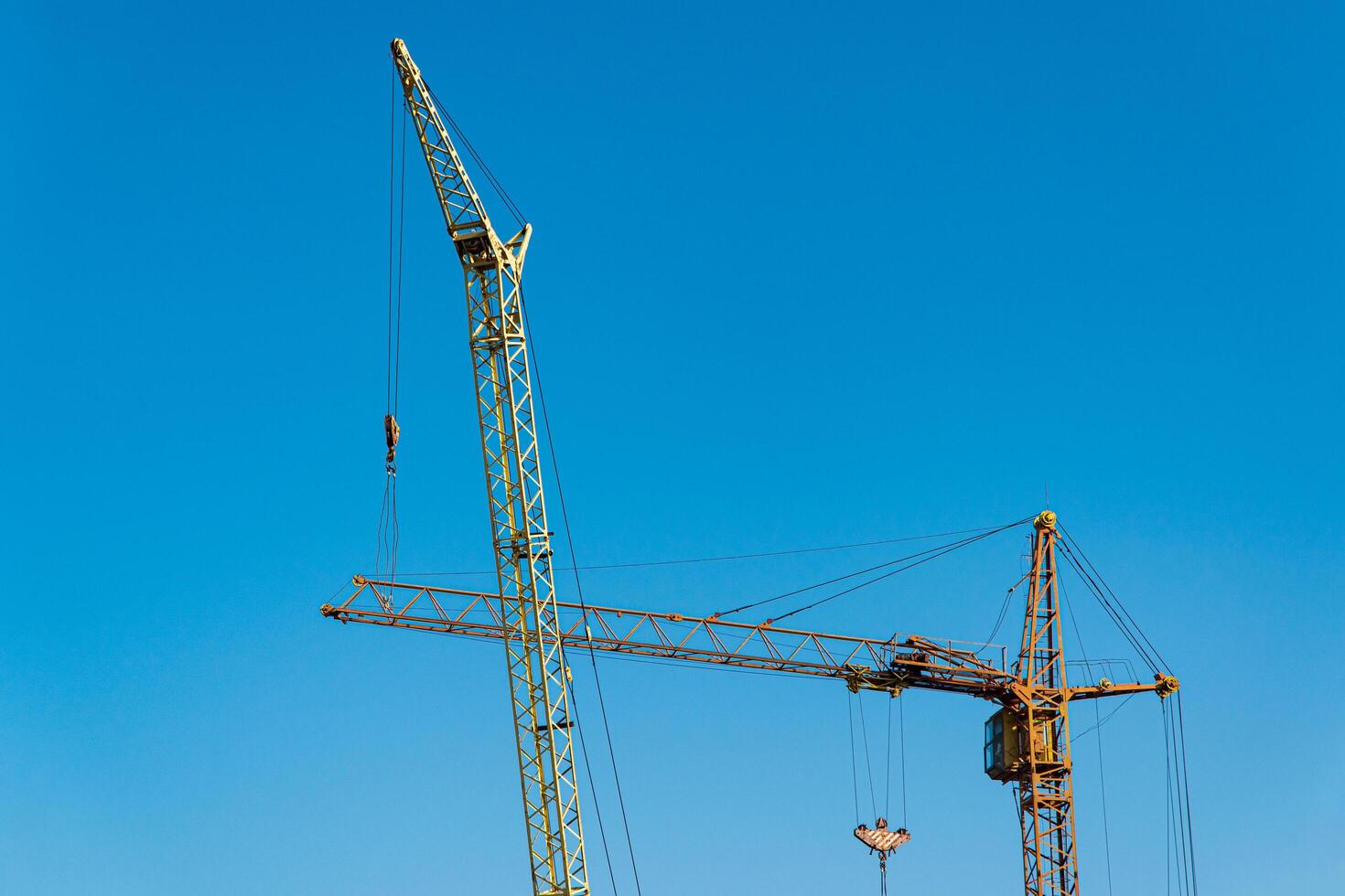 Construction cranes on sky background. Construction cranes for heavy lifting. Technology equipment photo