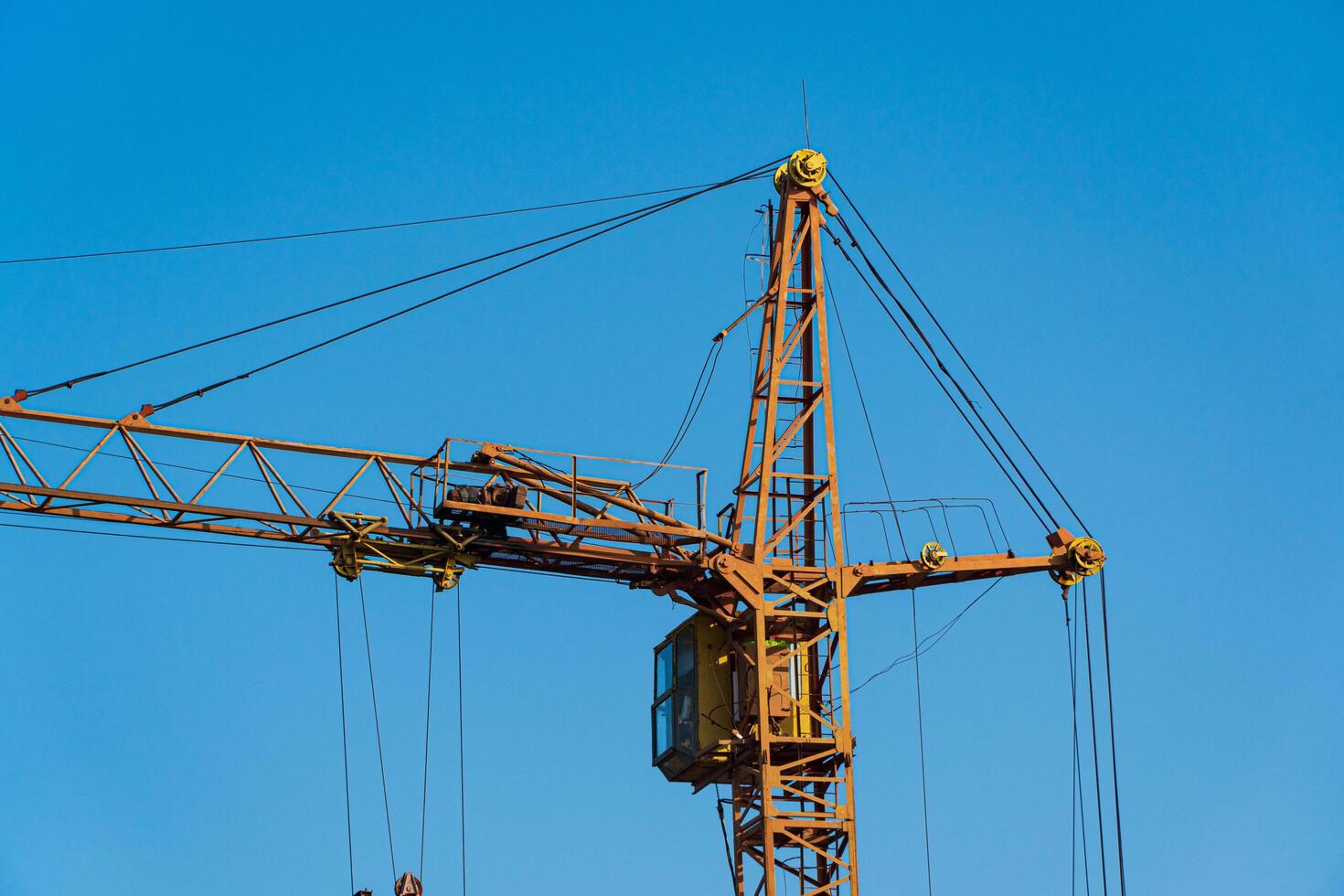 Construction crane on the background of the blue sky photo