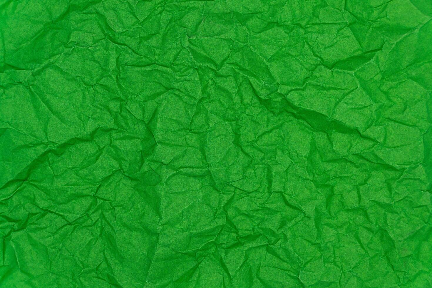 Green crumpled paper texture background. Wrinkled paper texture photo