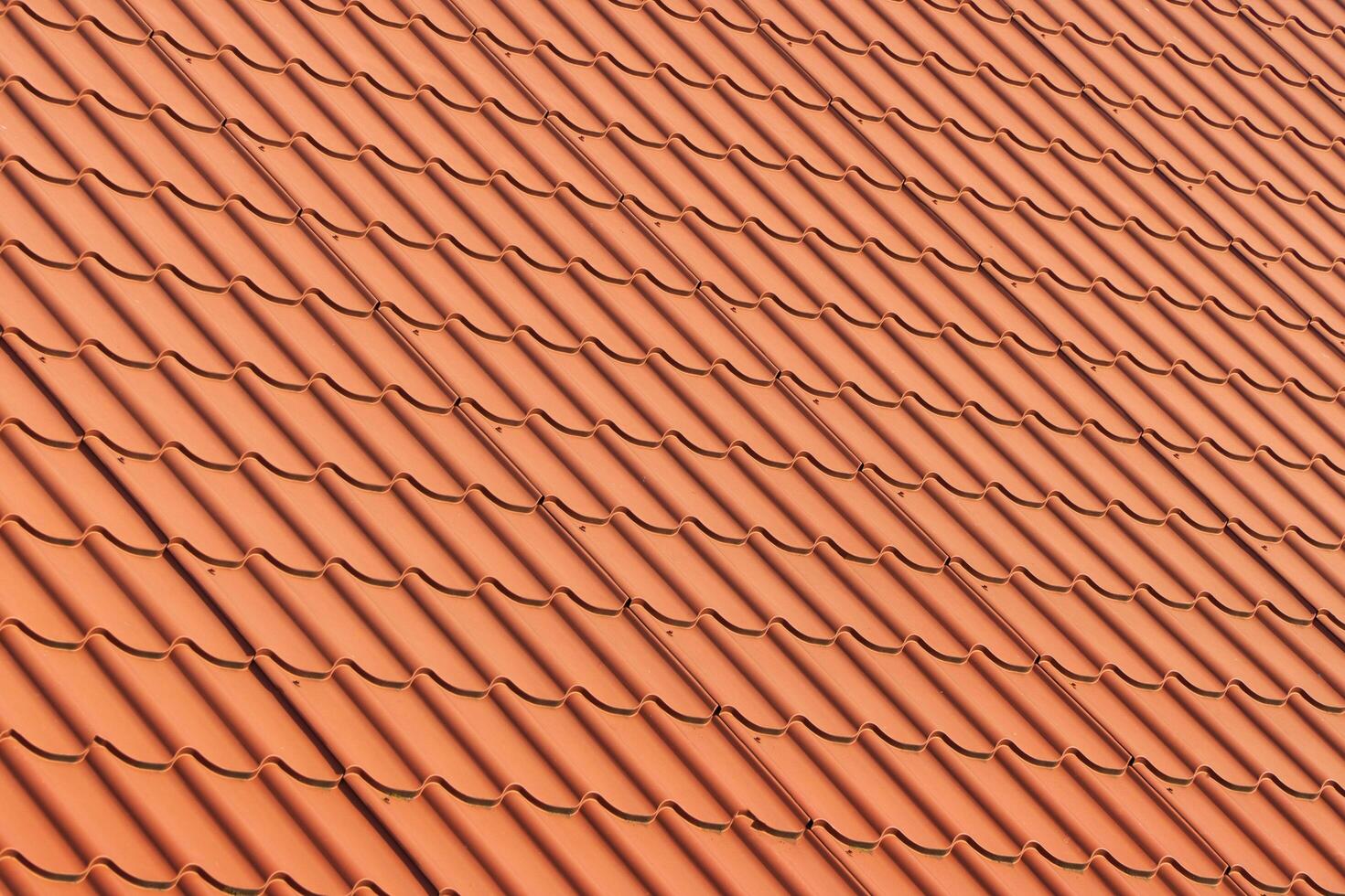 Red tiles roof. Red corrugated tile element of roof photo