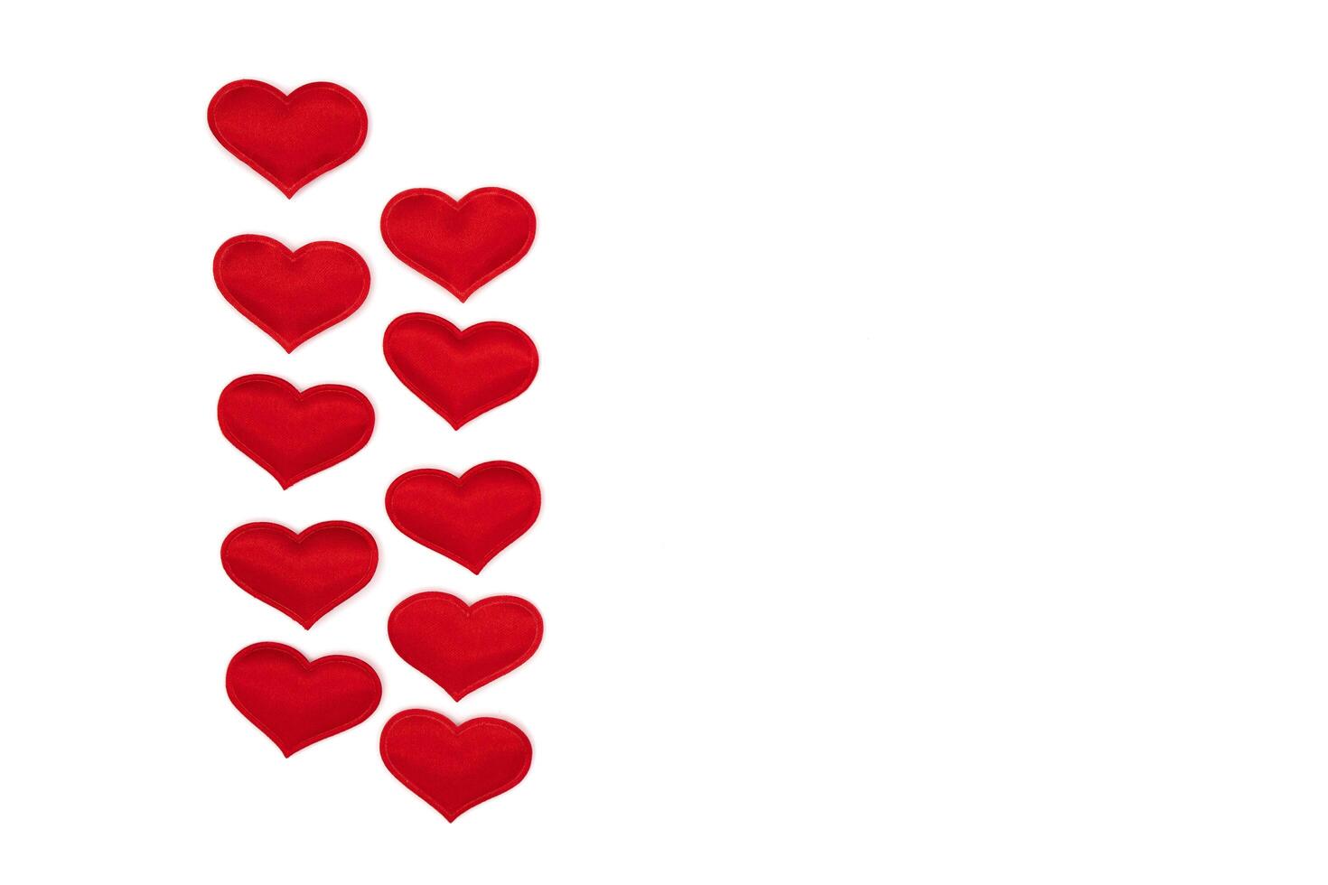 Little red hearts on a white photo