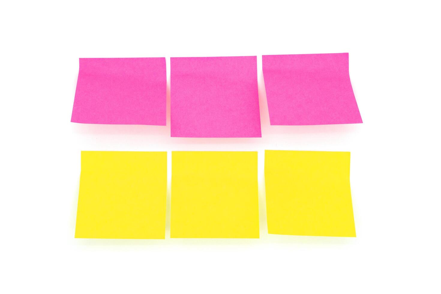 Reminder notes isolated on the white background. Yellow and pink sticky notes photo
