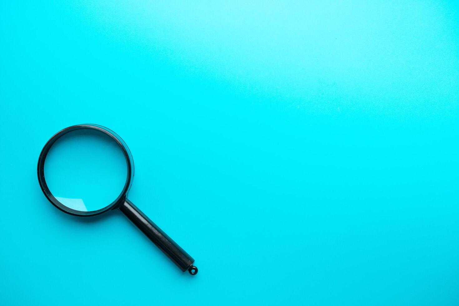 Magnifying glass on blue background. Top view. Flat lay. Copy space. photo