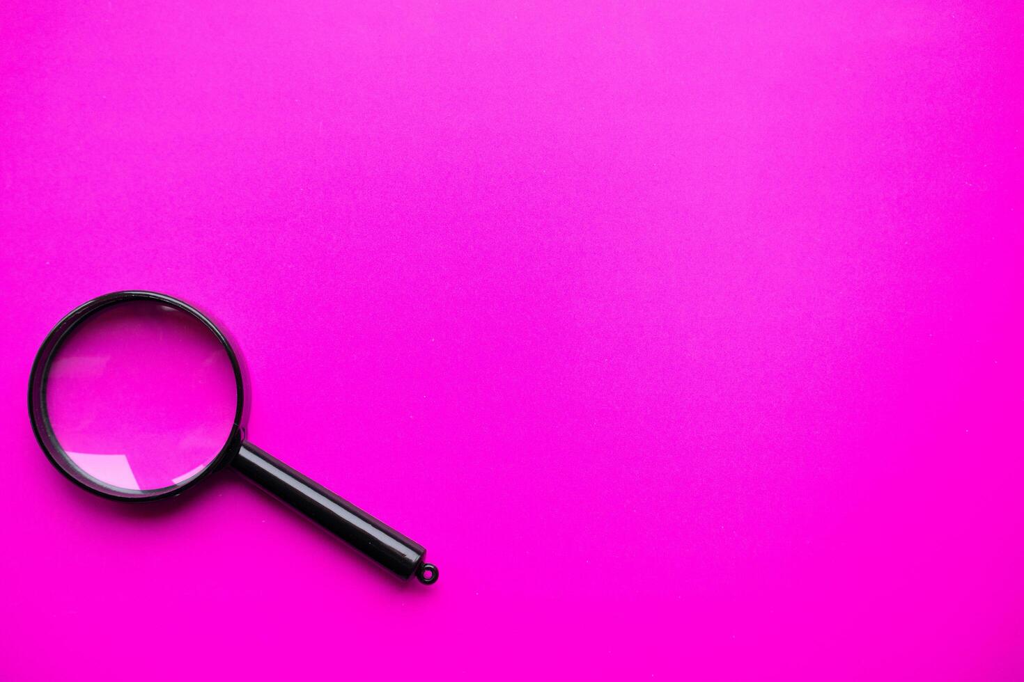 Magnifying glass on magenta background. Minimal creative concept photo