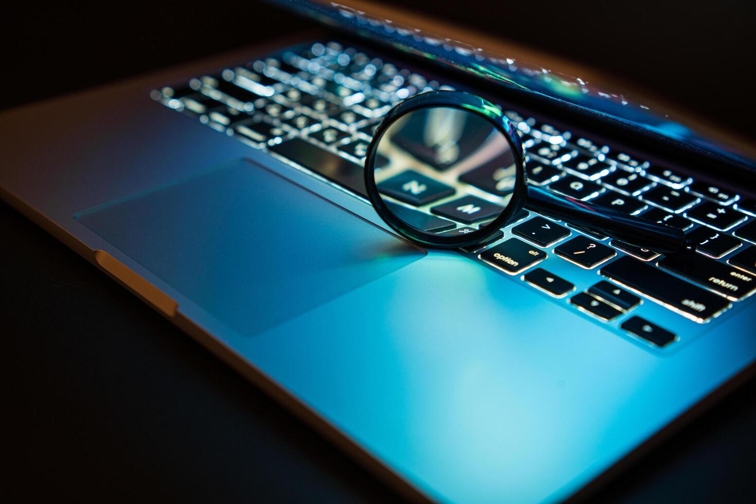 Laptop with magnifying glass. Search and analysis of information on the Internet. Selective focus photo