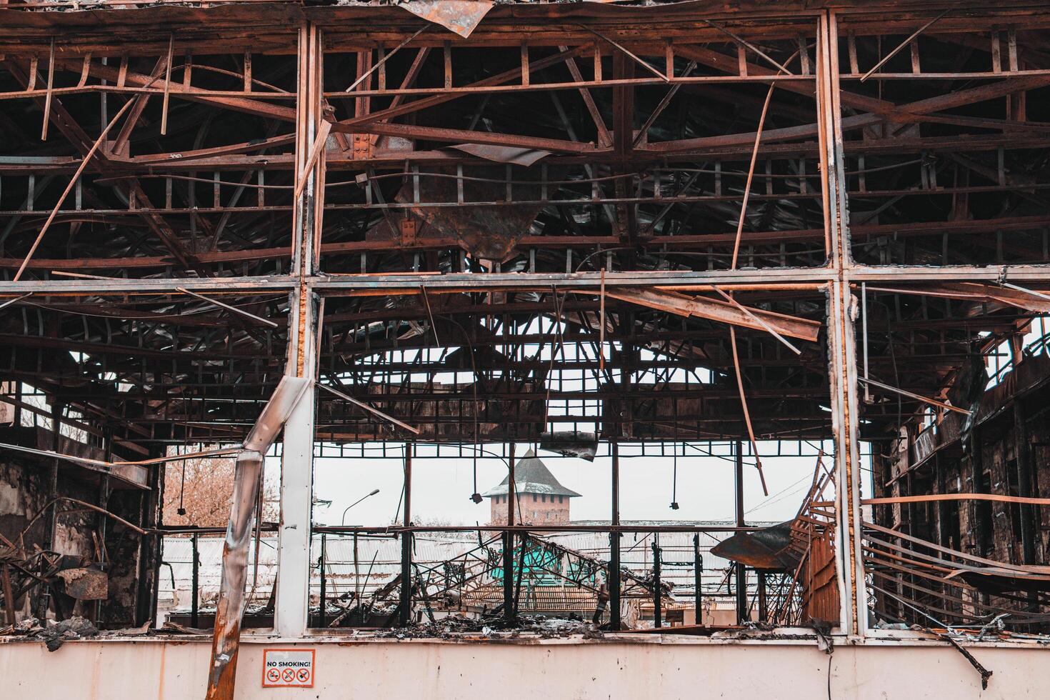 Industrial building after fire. A metal no smoking sign attached to a building photo