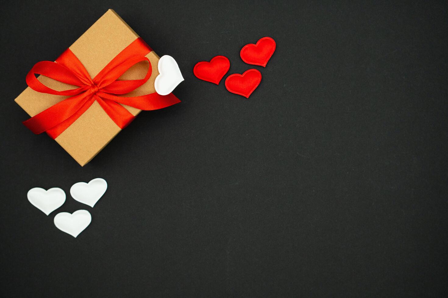 Beautiful valentines day background, with craft box with red and white hearts on black background photo