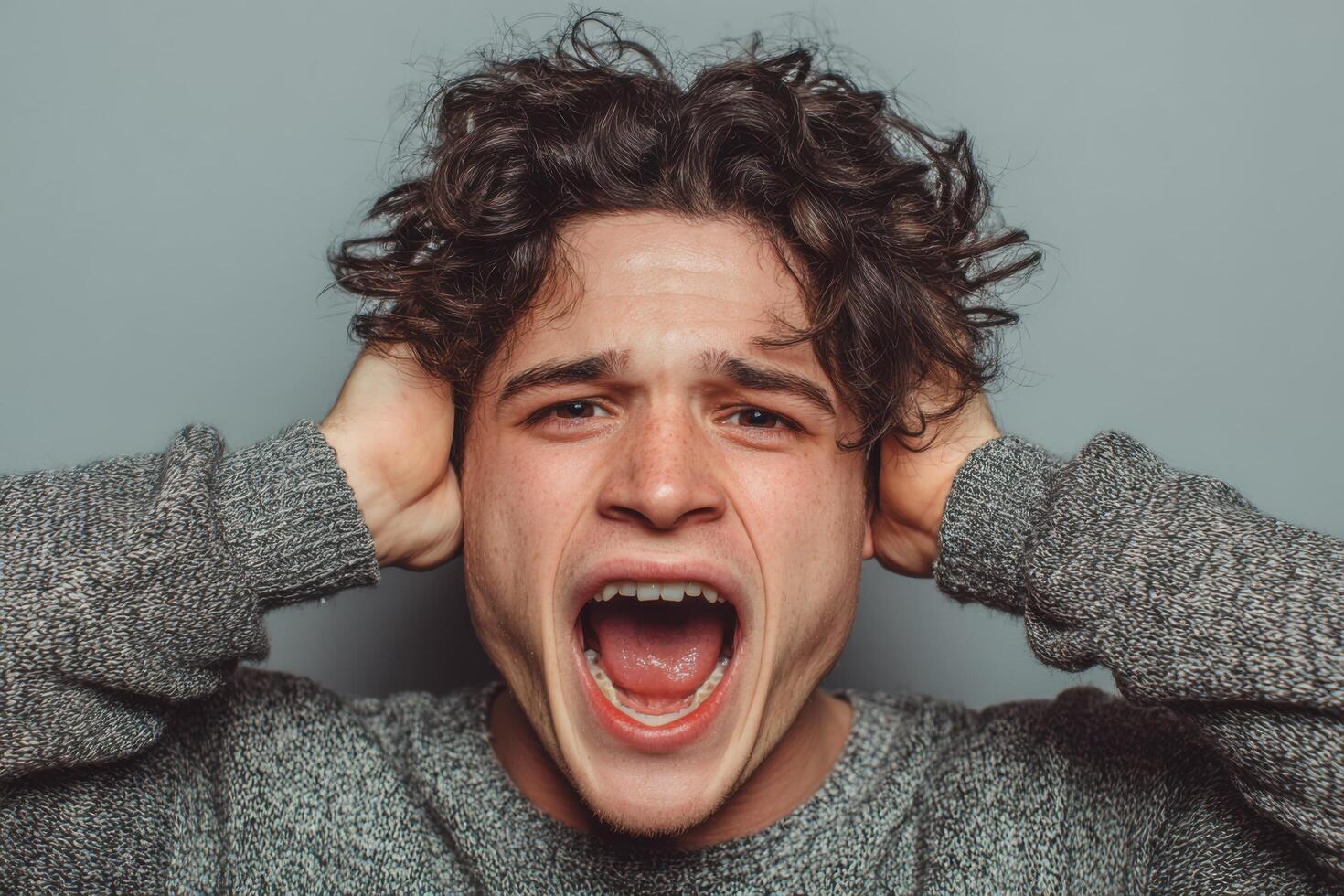 A man with his hands on his head and his mouth open photo
