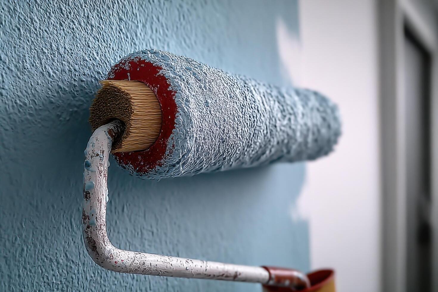 A paint roller and paint roller are on a wall photo