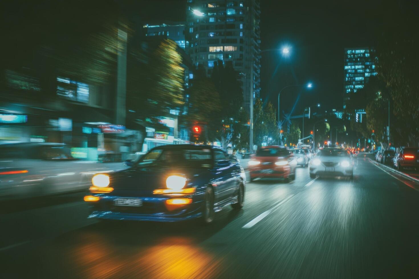 Cars driving on a busy city street at night photo