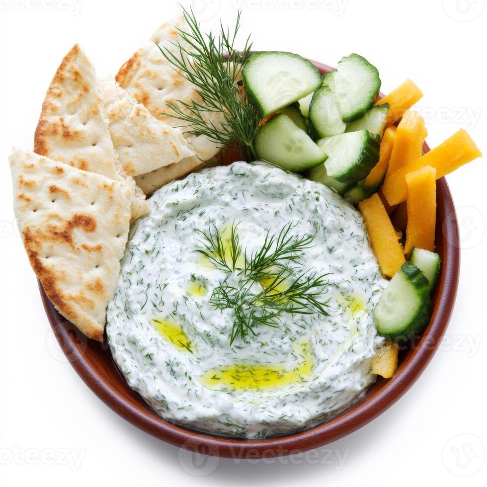 A refreshing Greek tzatziki dip, made with thick, creamy yogurt, finely grated cucumber, minced garlic, fresh dill, and a drizzle of extra virgin olive oil. Served with warm, toasted pita bread slices and a side of crunchy vegetable sticks for dipping. A photo