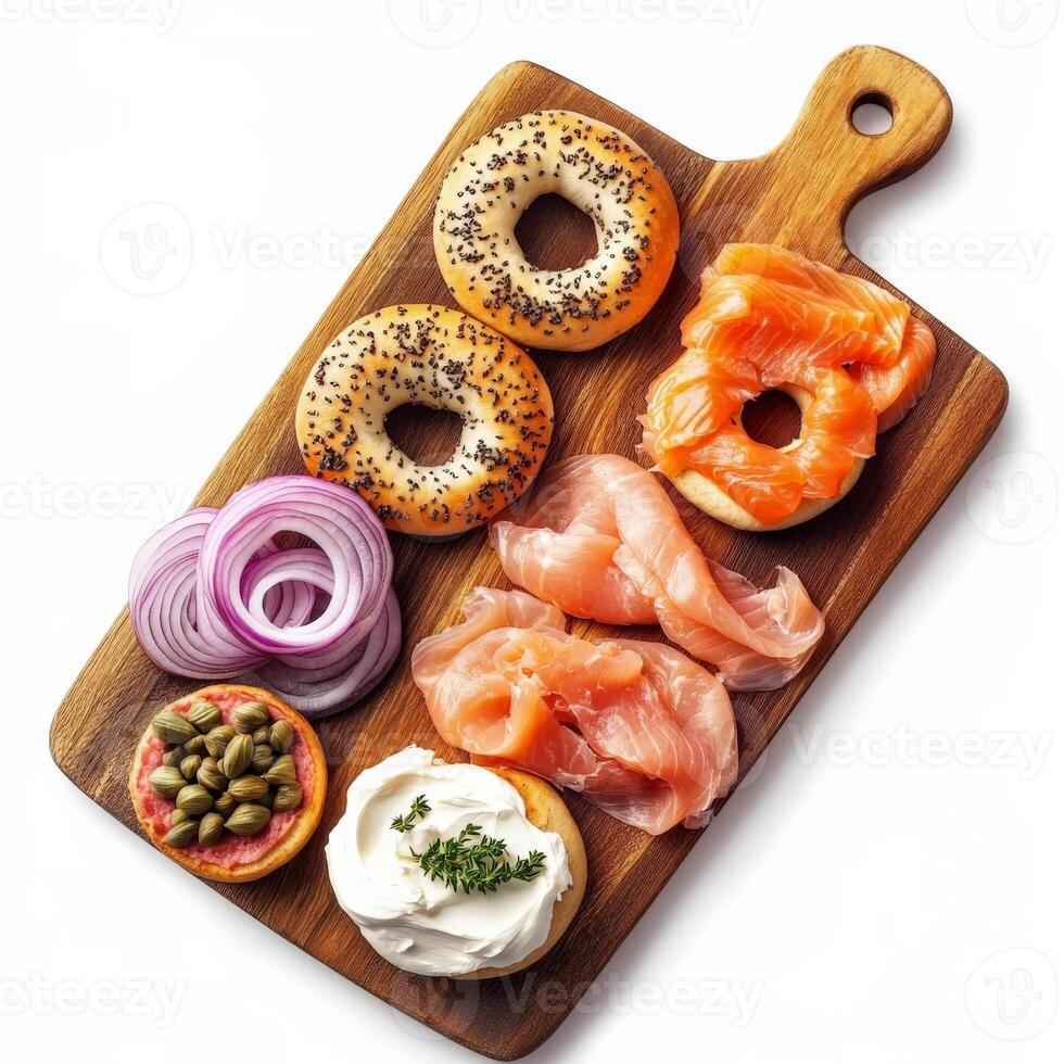 A wooden cutting board with an assortment of freshly baked bagels, served with cream cheese, smoked salmon, capers, and thinly sliced red onions. A classic breakfast option. Isolated on clean white background photo