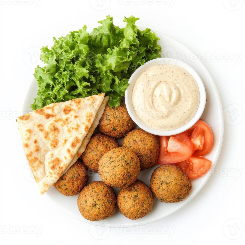 A platter of freshly made falafel balls, deep-fried to a crispy golden brown, served with a side of creamy tahini sauce and fresh pita bread. A delicious Middle Eastern favorite. Isolated on clean white background photo