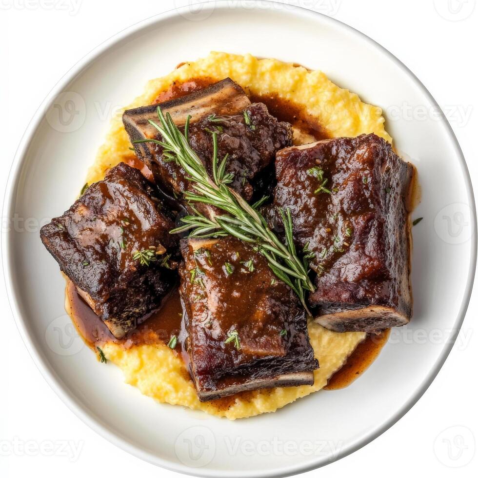 A plate of braised short ribs with polenta, featuring tender braised short ribs cooked in a rich red wine sauce, served over creamy polenta and garnished with fresh rosemary, a hearty and comforting Italian dish, isolated on clean white background. photo