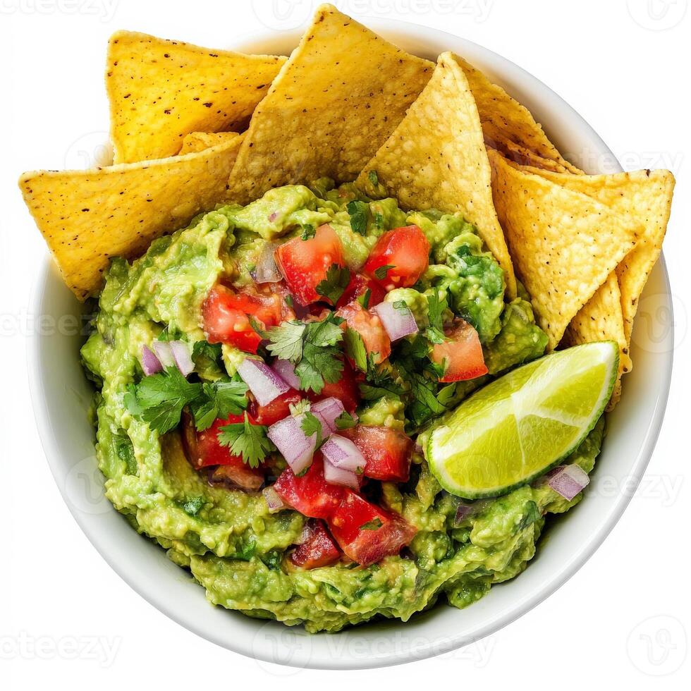 A bowl of fresh guacamole made with mashed avocados, diced tomatoes, onions, cilantro, and a squeeze of lime juice. The vibrant green dip is served with crispy tortilla chips for a classic Mexican appetizer. Isolated on clean white background photo