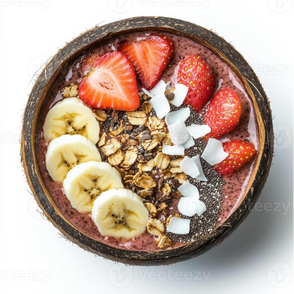 A vibrant smoothie bowl topped with sliced bananas, strawberries, shredded coconut, chia seeds, and granola, served in a coconut shell. A tropical and nutritious breakfast. Isolated on clean white background photo