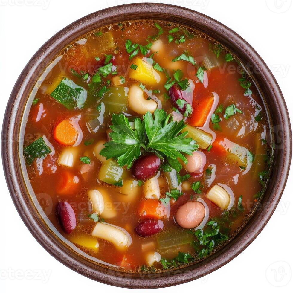 Vegetarian soup in a bowl with herbs and vegetables isolated on white background photo