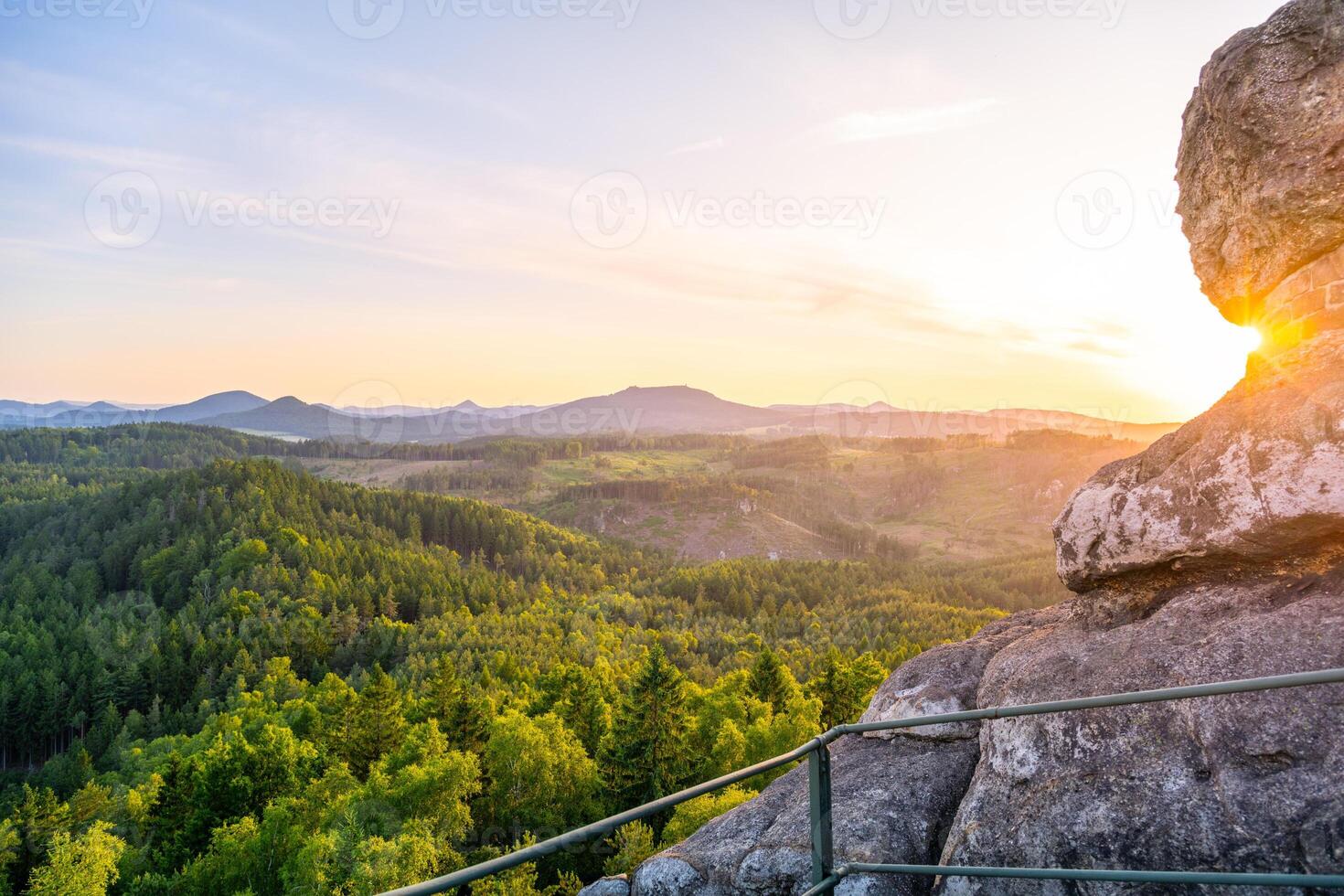 The Lusatian Mountains offer a breathtaking view from Popov Cliffs during the evening. The sandstone formations shine under the soft glow of the sunset, creating a peaceful atmosphere. photo