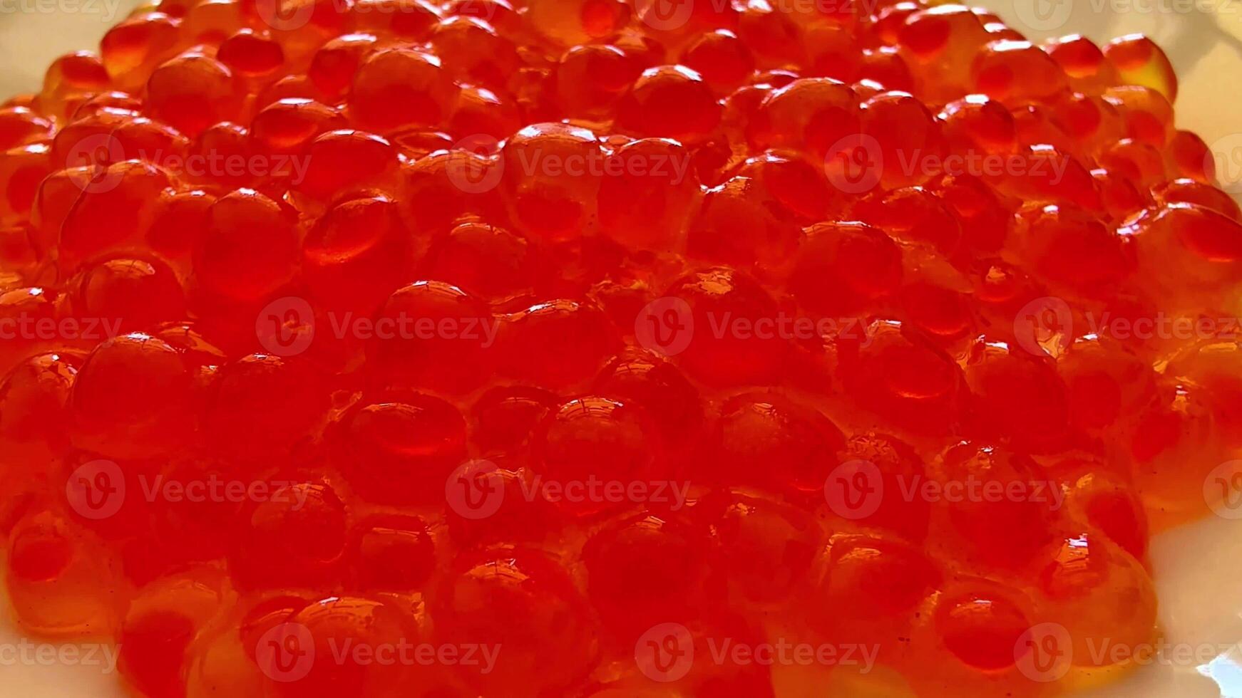 Closeup of glossy red fish caviar on a pristine white plate, elegantly arranged for a perfect presentation photo