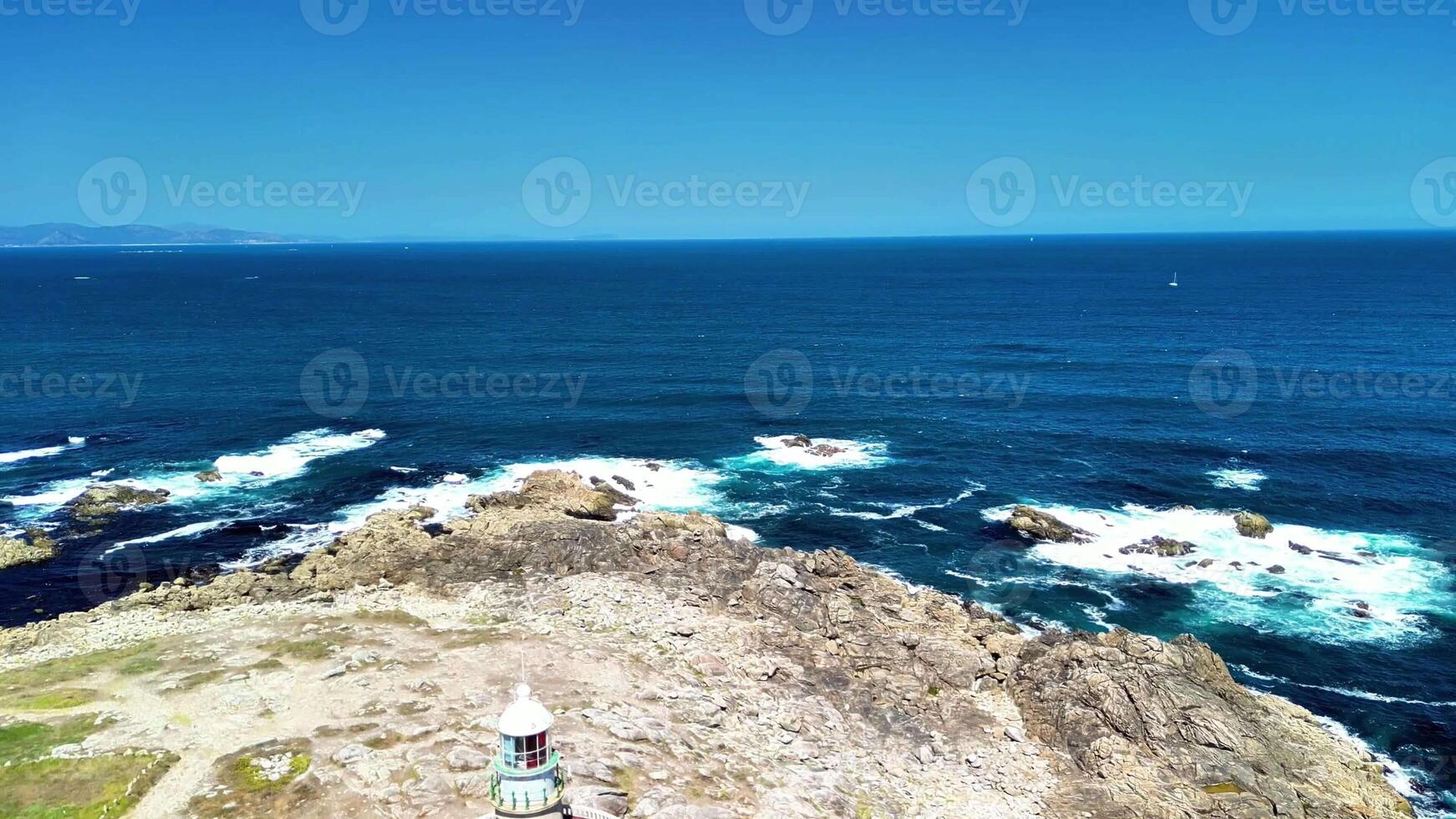Enjoy a stunning aerial view of a rocky coastal area by the ocean under clear blue skies and crashing waves photo