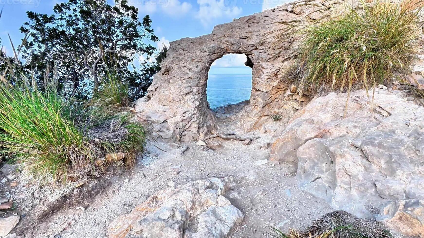 A hole in the rock on the edge of a cliff photo
