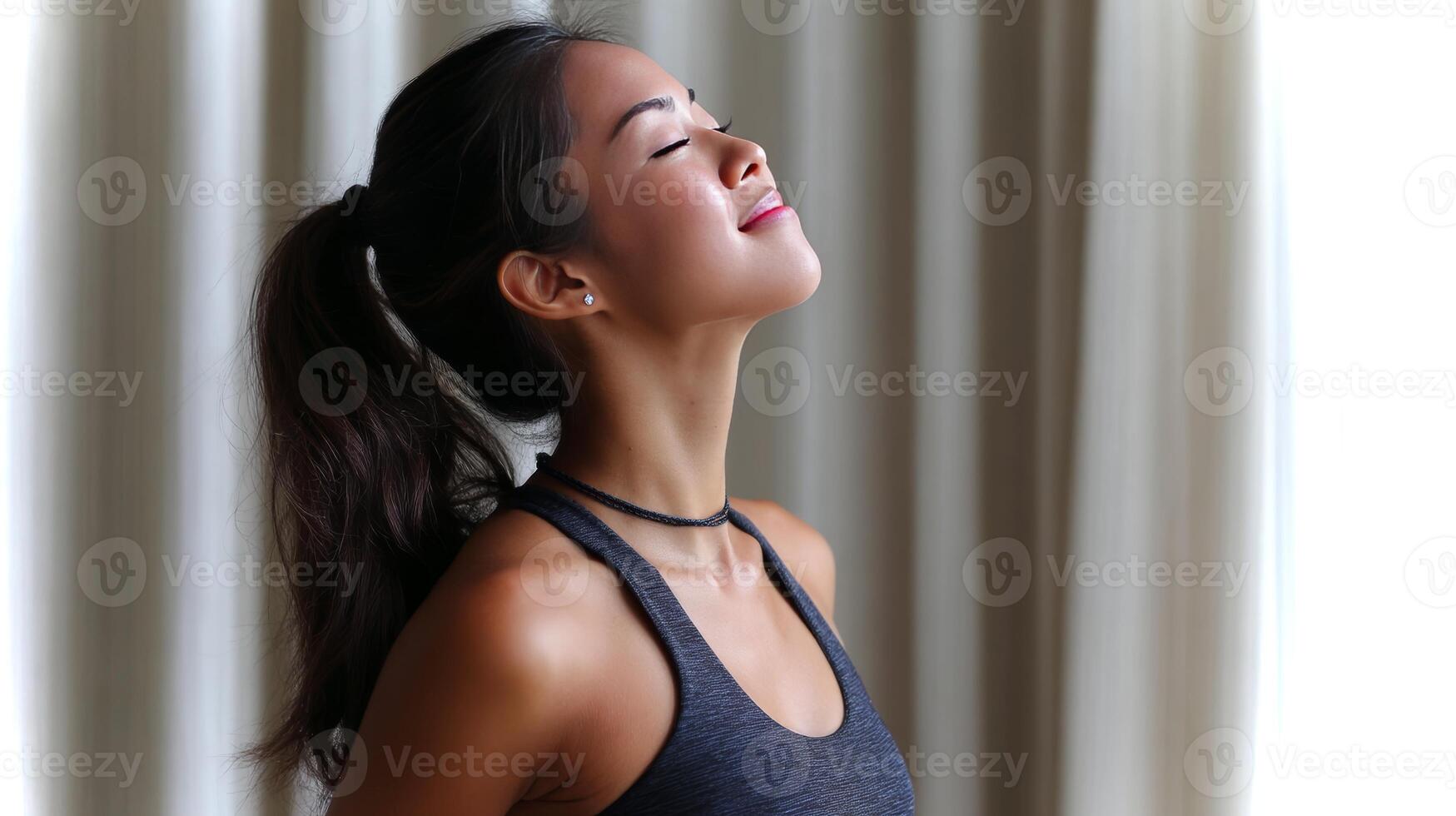 An Asian girl practices the camel pose in a serene indoor setting, exuding calmness and focus while enhancing her flexibility and strength during yoga. photo