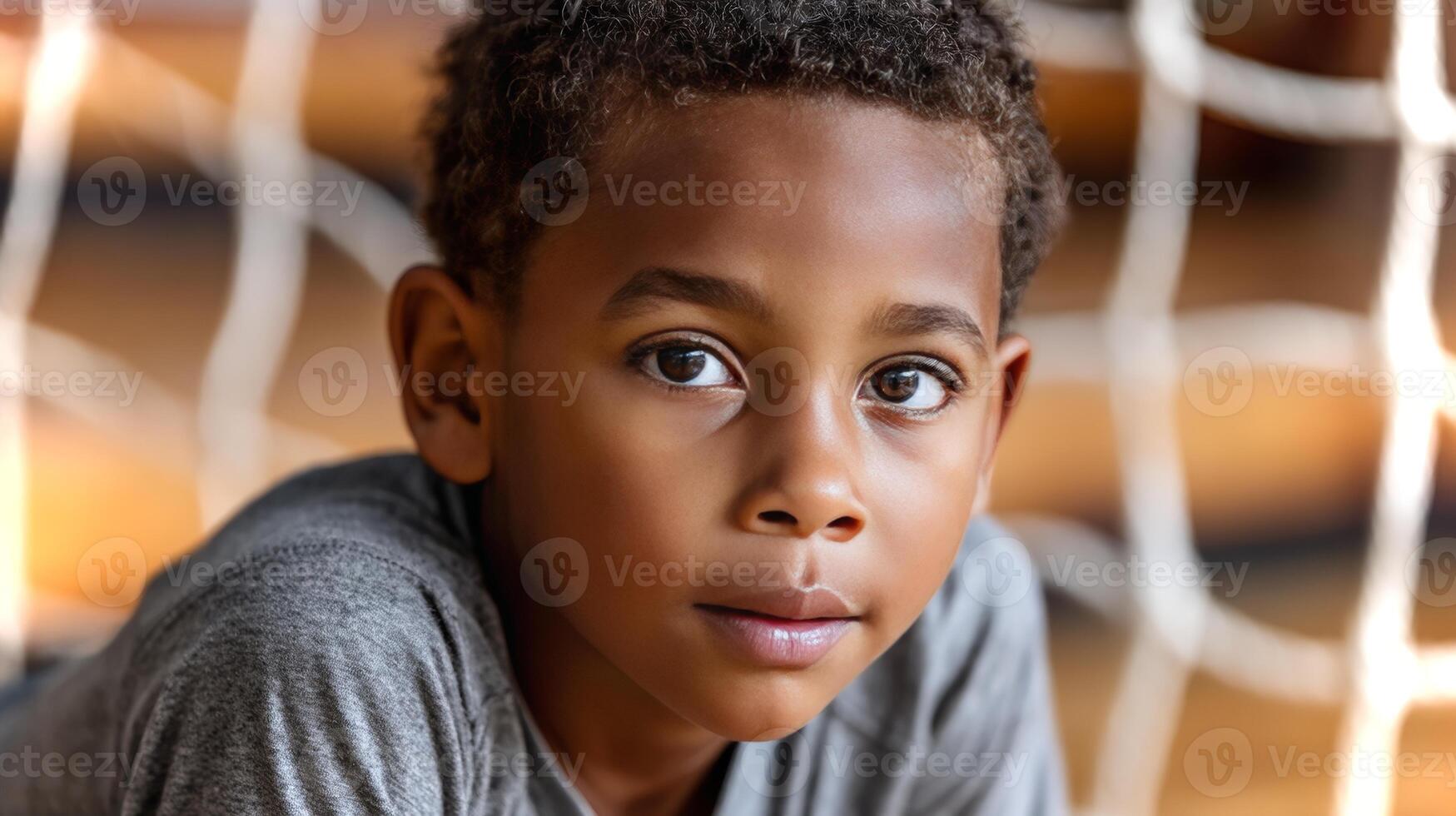 A black boy is crouching in a ready position beside a goal net, displaying focus and determination typical in sports. The setting captures the excitement of play. photo