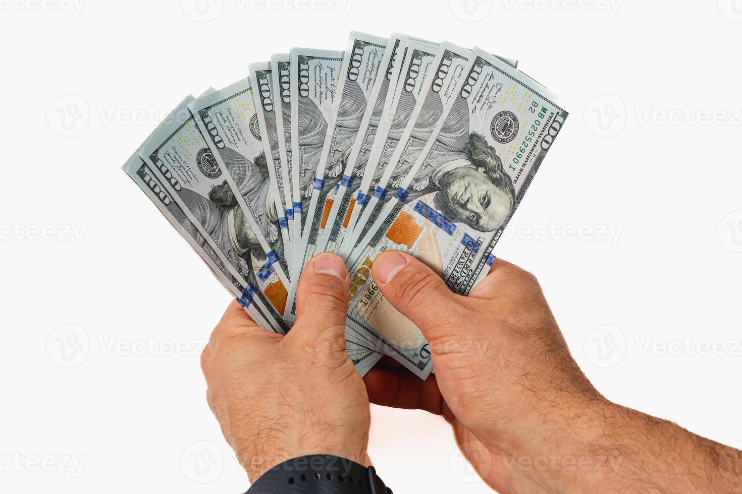 Hands holding a fan of hundred dollar bills in bright light photo