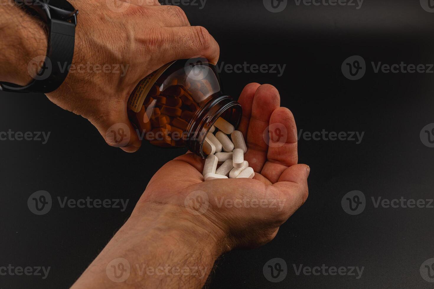 Pouring dietary supplements into a palm for consumption photo