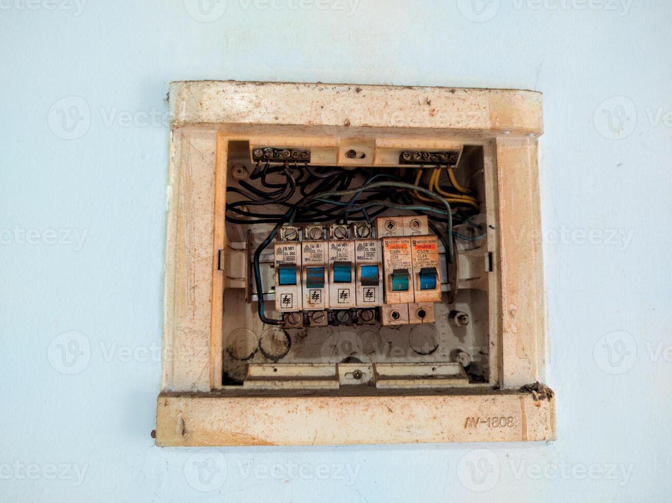 an old white electrical box with wires and a fuse on a white wall photo