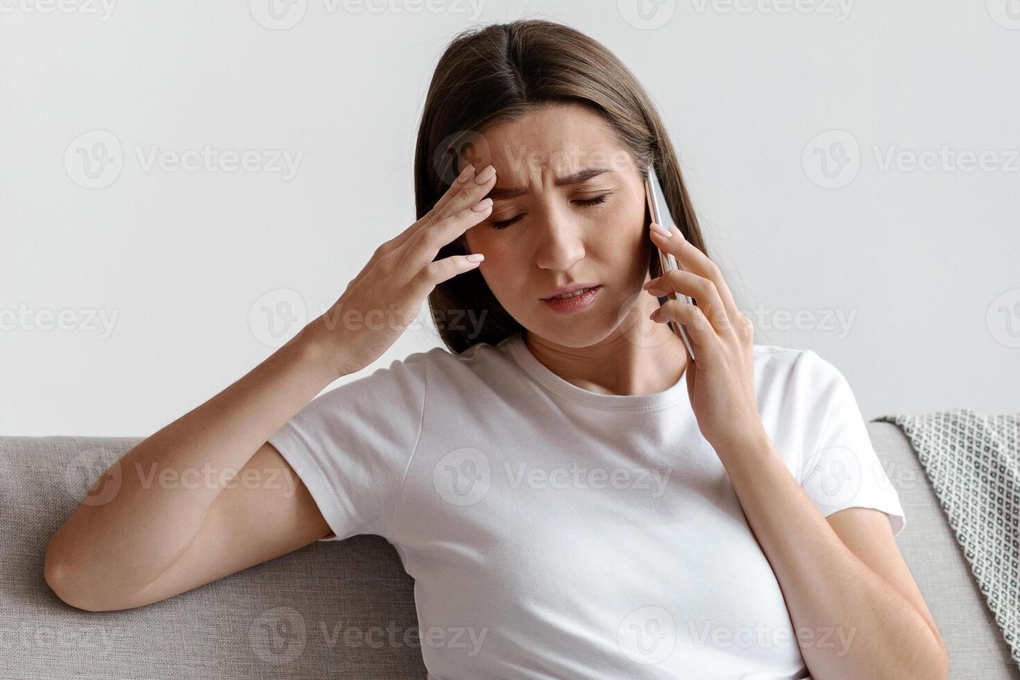 Pregnant Woman Feeling Unwell While Talking On Cellphone At Home, Having Strong Headache And Suffering From Migraine While Speaking On Mobile Phone, Sitting On Couch In Living Room, Free Space photo