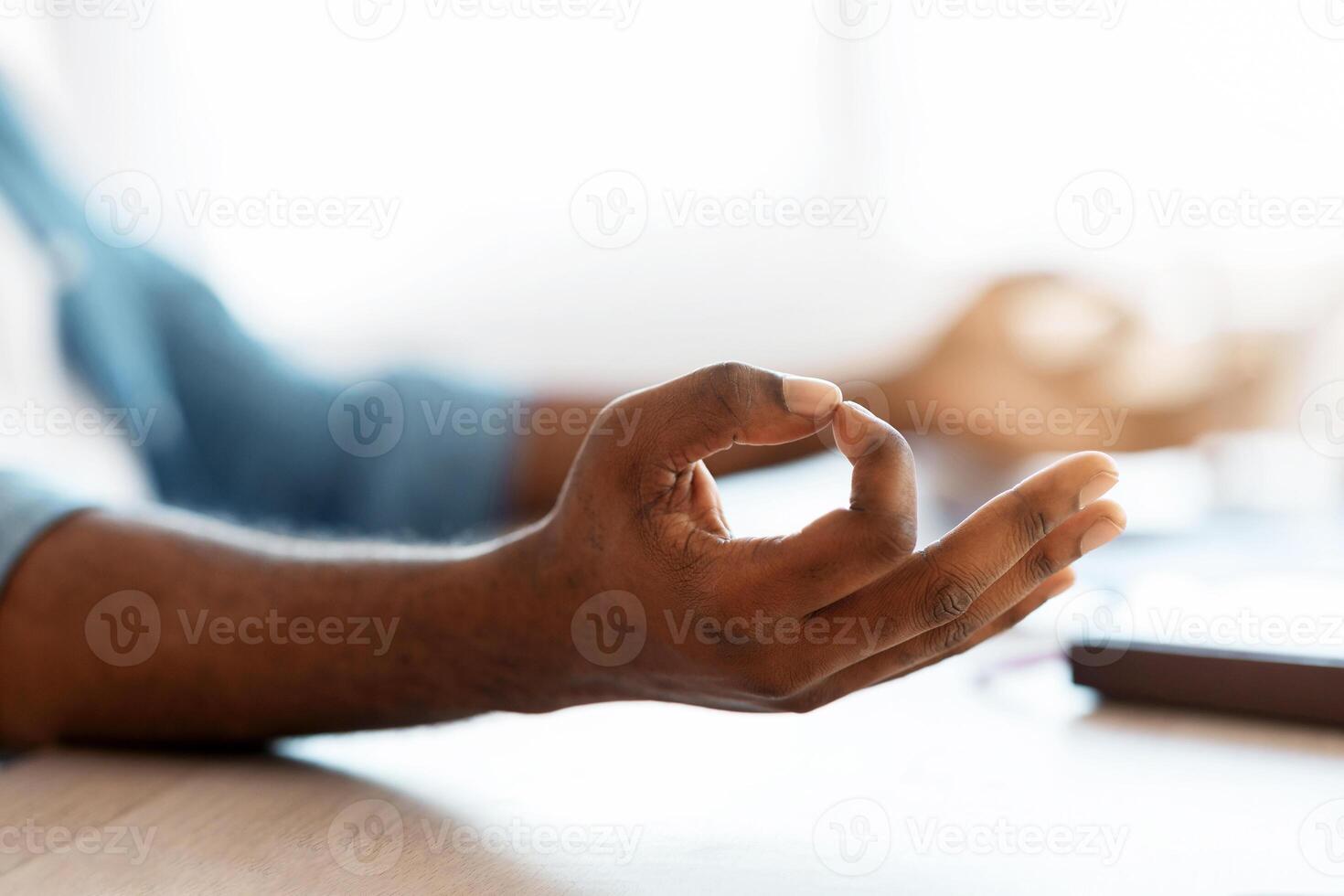 Zen Time. Closeup Shot Of Unrecognizable Black Male Meditating At Desk, African American Man Making Mudra Gesture With Hands, Coping With Stress At Work, Cropped Image With Selective Focus photo